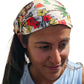 a woman wearing a hula girl hawaiian design  bandana looking down at her cell phone